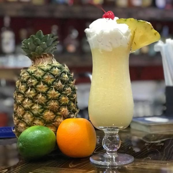 Pina Colada with pineapple, lime, and orange on a bar at Los Mariachis Mexican Restaurant.